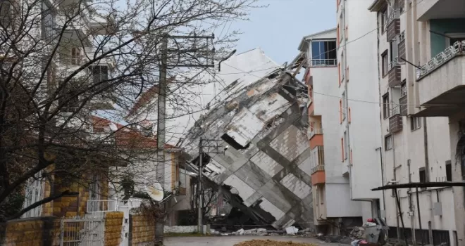 Depremde camları dahi kırılmadan yan yatan binanın yıkımı sürüyor